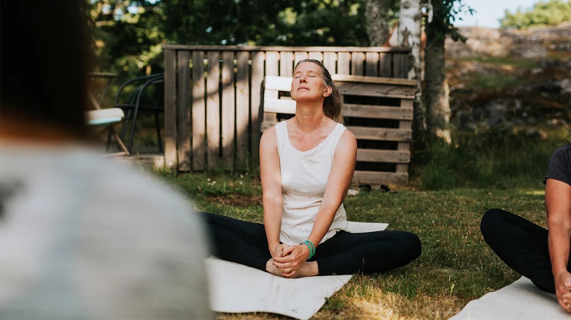 older woman does yoga outside